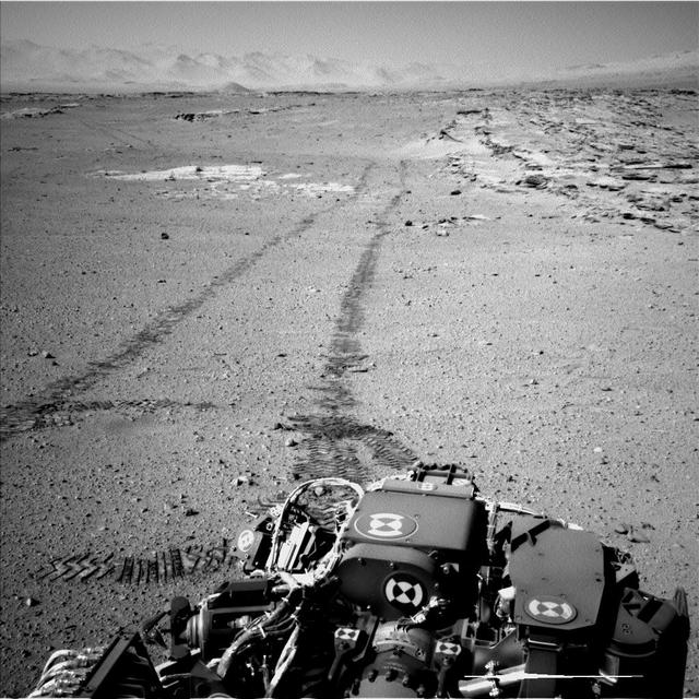 On Feb. 19, 2014, NASA Curiosity Mars rover looked back after finishing a long drive. The rows of rocks just to the right of the fresh wheel tracks in this view are an outcrop called Junda. This view is looking toward the east-northeast.