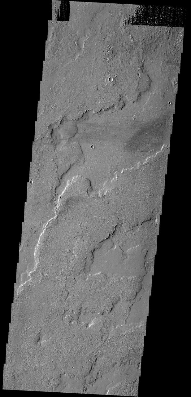 This image shows a small portion of the extensive lava flows created by the large Tharsis volcanoes as seen by NASA 2001 Mars Odyssey spacecraft. These flows are located north east of Ascraeus Mons.