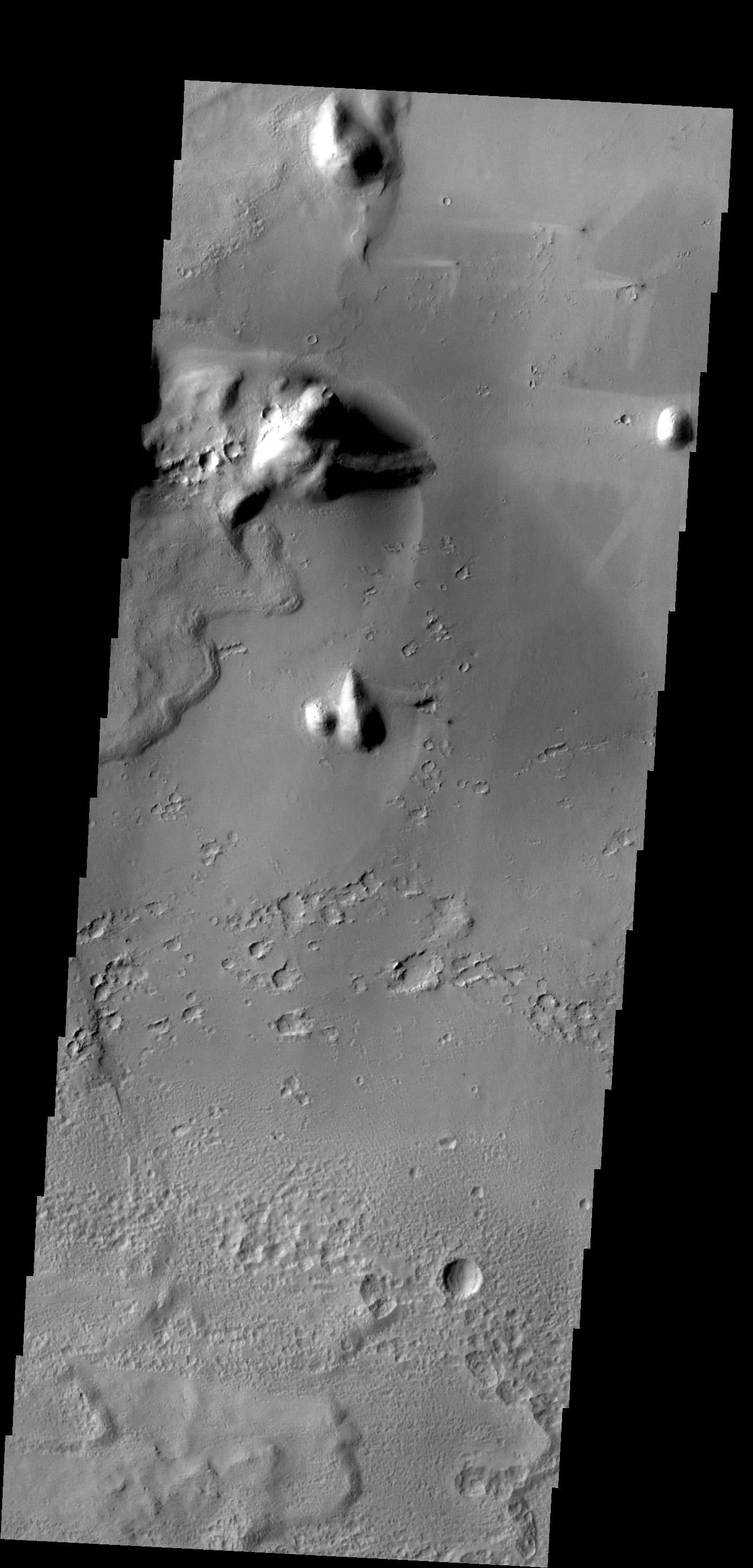 Bright windstreaks are located around several small craters at the top of this image captured by NASA 2001 Mars Odyssey spacecraft.