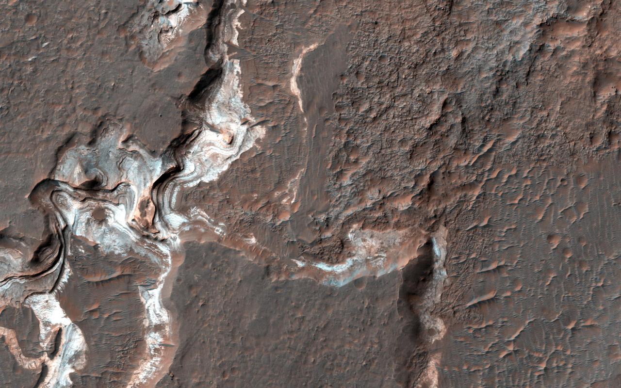 This image shows some bright layered deposits exposed within a linear trough along the floor of the Ladon Basin as seen by NASA Mars Reconnaissance Orbiter.