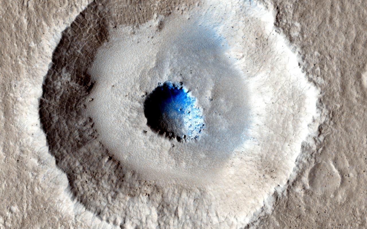 The crater in the center of this HiRISE image from NASA Mars Reconnaissance Orbiter is unusual because there is a wide, flat bench, or terrace, between the outer rim and the inner section, making it appear somewhat like a bullseye.