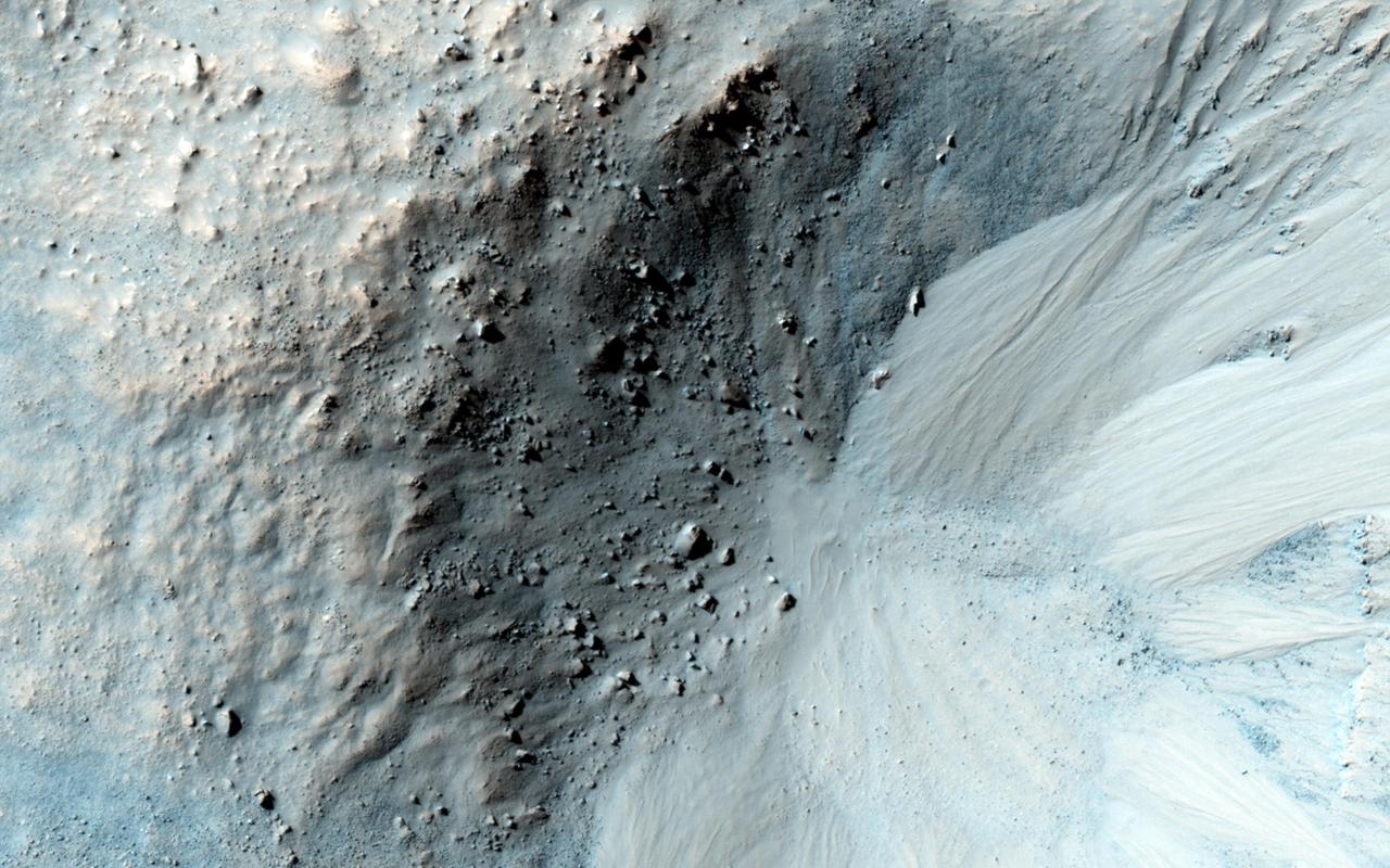 This impact crater in the region of Mars called Libya Montes, observed by NASA Mars Reconnaissance Orbiter, shows typical gullies with alcoves at the top, channels, and depositional fans at the bottom.
