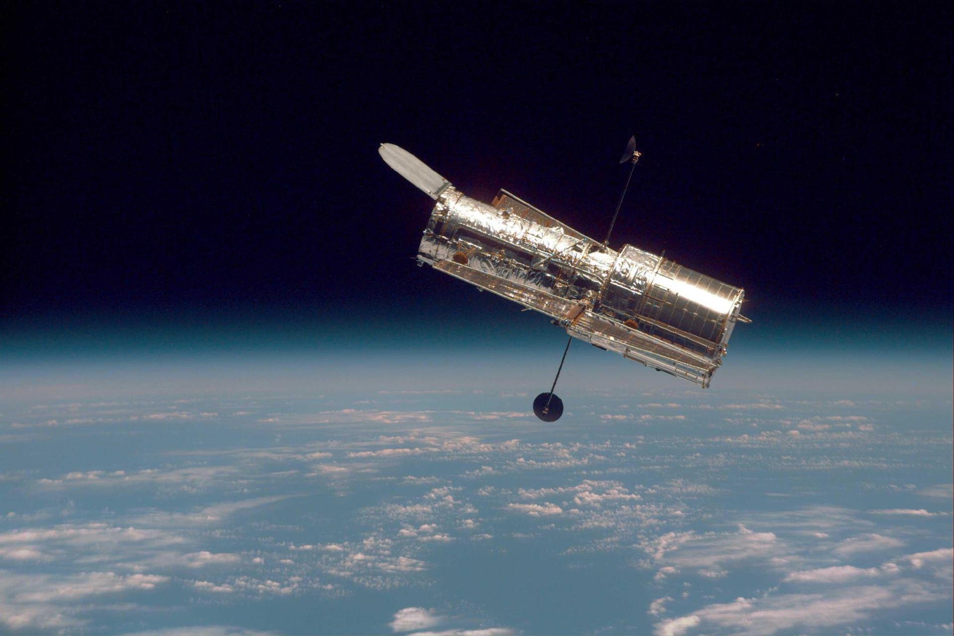 The Hubble Space Telescope hovers at the boundary of Earth and space in this picture, taken after Hubble second servicing mission in 1997.