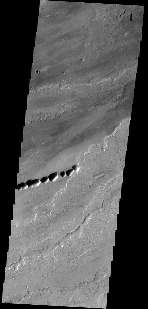 The lava flows in this image from NASA 2001 Mars Odyssey spacecraft most likely originated from Ascraeus Mons, one of the large Tharsis volcanos.