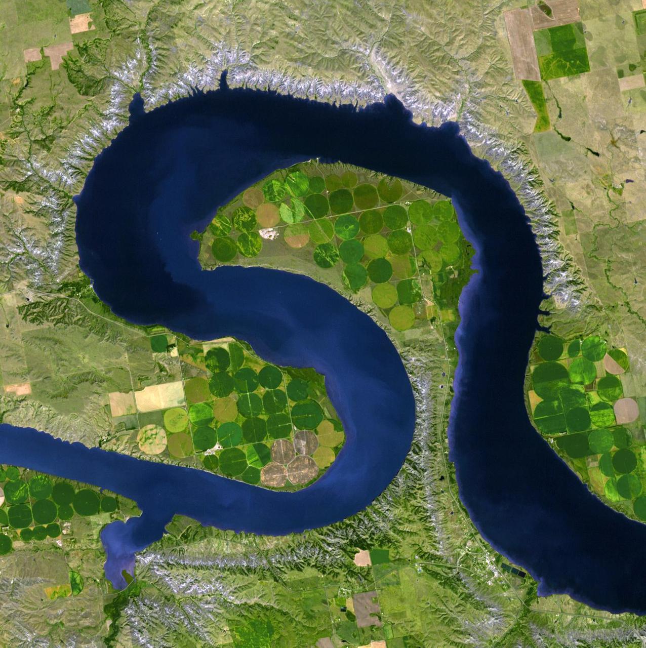 NASA Terra spacecraft views central South Dakota, where the Missouri River forms a meander bend, creating Lake Sharpe. Eventually, the Missouri River will cut through the skinny peninsula, creating a shorter path.