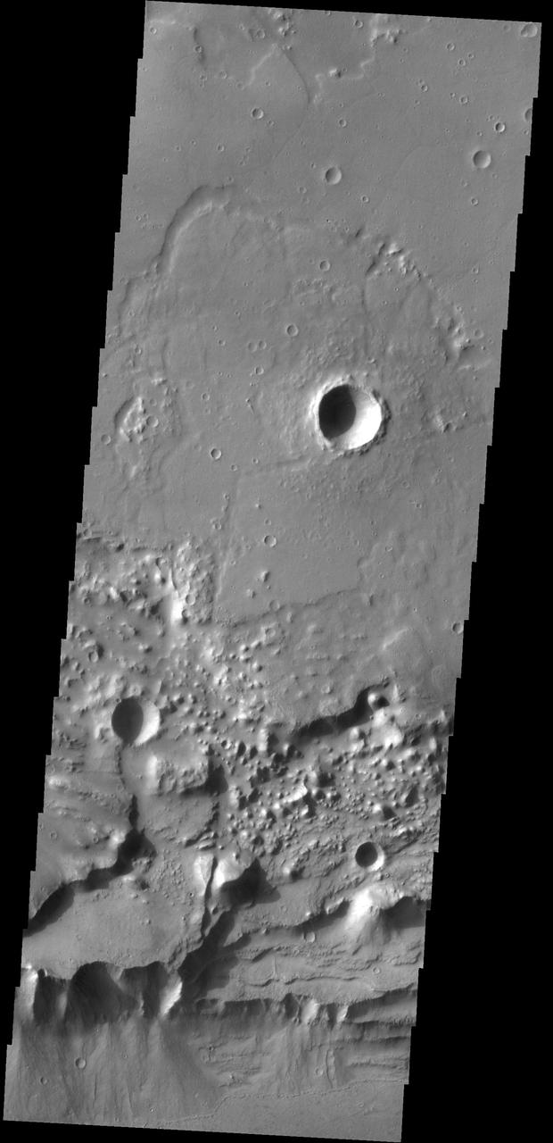 Triangular shaped deposits at cliff edges are termed alluvial fans. Alluvial fans typically form in arid regions were water flow is limited, so deposits of material are not washed away as seen by NASA 2001 Mars Odyssey spacecraft.