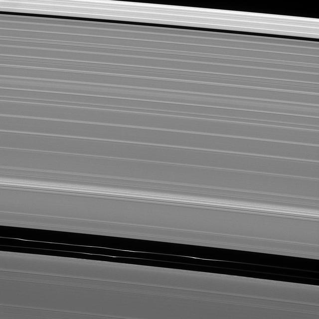 Although it appears empty from a distance, the Encke gap in Saturn A ring has three ringlets threaded through it, two of which are visible here from NASA Cassini spacecraft. Each ringlet has dynamical structure such as the clumps seen in this image. The clumps move about and even appear and disappear, in part due to the gravitational effects of Pan. This view looks toward the sunlit side of the rings from about 27 degrees above the ringplane. The image was taken in visible light with the Cassini spacecraft narrow-angle camera on May 11, 2013. The view was obtained at a distance of approximately 199,000 miles (321,000 kilometers) from Saturn and at a Sun-Saturn-spacecraft, or phase, angle of 121 degrees. Image scale is 1 mile (2 kilometers) per pixel. http://photojournal.jpl.nasa.gov/catalog/PIA18277