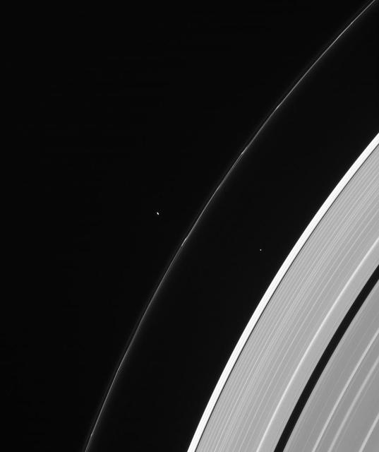 Are the moons tiny or are the rings vast? Both, in a way! The moons visible in this image from NASA Cassini spacecraft, Pandora and Atlas, are quite small by astronomical standards, but the rings are also enormous. From one side of the planet to the other, the A ring stretches over 170,000 miles 270,000 km. Pandora (50 miles, or 81 kilometers, across) orbits in the vicinity of the F ring, along with neighboring Prometheus, which is not visible in this image. These moons interact frequently with the narrow F ring, producing channels and streamers and other interesting features. Atlas (19 miles, or 30 kilometers across) orbits between the A ring and F ring in the Roche division. This view looks toward the sunlit side of the rings from about 34 degrees above the ringplane. The image was taken in visible light with the Cassini spacecraft narrow-angle camera on Feb. 17, 2014. The view was obtained at a distance of approximately 1.7 million miles (2.8 million kilometers) from Pandora and at a Sun-Pandora-spacecraft, or phase, angle of 110 degrees. Image scale is 11 miles (17 kilometers) per pixel. http://photojournal.jpl.nasa.gov/catalog/PIA18279
