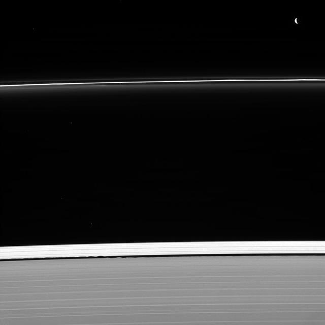 Two masters of their craft are caught at work shaping Saturn's rings. Pandora (upper right) sculpts the F ring, as does nearby Prometheus (not seen in this image). Meanwhile, Daphnis is busy holding open the Keeler gap (bottom center), its presence revealed here by the waves it raises on the gap's edge. The faint moon is located where the inner and outer waves appear to meet. Also captured in this image, shining through the F ring above the image center, is a single star. Although gravity is by its very nature an attractive force, moons can interact with ring particles in such a way that they effectively push ring particles away from themselves. Ring particles experience tiny gravitational "kicks" from these moons and subsequently collide with other ring particles, losing orbital momentum. The net effect is for moons like Pandora (50 miles or 81 kilometers across) and Daphnis (5 miles or 8 kilometers across) to push ring edges away from themselves. The Keeler gap is the result of just such an interaction. This view looks toward the unilluminated side of the rings from about 50 degrees below the ringplane. The image was taken in visible light with the Cassini spacecraft narrow-angle camera on Jan. 30, 2013. http://photojournal.jpl.nasa.gov/catalog/PIA18298