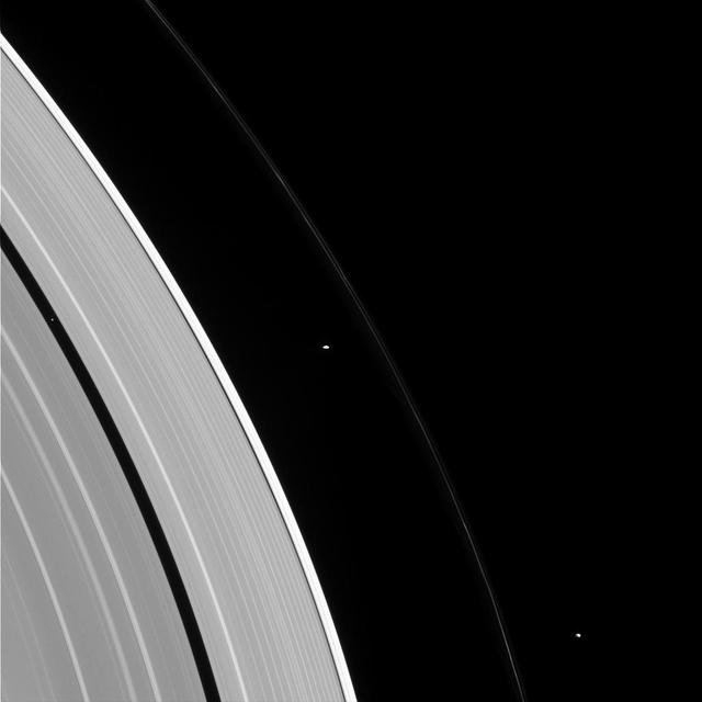 People with similar jobs or interests hold conventions and meetings, so why shouldn't moons? Pandora, Prometheus, and Pan -- seen here, from right to left -- also appear to be holding some sort of convention in this image.  Some moons control the structure of nearby rings via gravitational "tugs." The cumulative effect of the moon's tugs on the ring particles can keep the rings' edges from spreading out as they are naturally inclined to do, much like shepherds control their flock. Pan is a prototypical shepherding moon, shaping and controlling the locations of the inner and outer edges of the Encke gap through a mechanism suggested in 1978 to explain the narrow Uranian rings. However, though Prometheus and Pandora have historically been called "the F ring shepherd moons" due to their close proximity to the ring, it has long been known that the standard shepherding mechanism that works so well for Pan does not apply to these two moons.  The mechanism for keeping the F ring narrow, and the roles played -- if at all -- by Prometheus and Pandora in the F ring's configuration are not well understood. This is an ongoing topic for study by Cassini scientists.  This view looks toward the sunlit side of the rings from about 29 degrees above the ringplane. The image was taken in visible light with the Cassini spacecraft narrow-angle camera on Jan. 2, 2015.  The view was obtained at a distance of approximately 1.6 million miles (2.6 million kilometers) from the rings and at a Sun-ring-spacecraft, or phase, angle of 86 degrees. Image scale is 10 miles (15 kilometers) per pixel.  http://photojournal.jpl.nasa.gov/catalog/pia18306