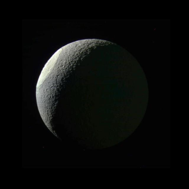 With the expanded range of colors visible to Cassini's cameras, differences in materials and their textures become apparent that are subtle or unseen in natural color views. Here, the giant impact basin Odysseus on Saturn's moon Tethys stands out brightly from the rest of the illuminated icy crescent. This distinct coloration may result from differences in either the composition or structure of the terrain exposed by the giant impact. Odysseus (280 miles, or 450 kilometers, across) is one of the largest impact craters on Saturn's icy moons, and may have significantly altered the geologic history of Tethys.  Tethys' dark side (at right) is faintly illuminated by reflected light from Saturn.  Images taken using ultraviolet, green and infrared spectral filters were combined to create this color view. North on Tethys (660 miles or 1,062 kilometers across) is up in this view.  The view was acquired on May 9, 2015 at a distance of approximately 186,000 miles (300,000 kilometers) from Tethys. Image scale is 1.1 mile (1.8 kilometers) per pixel.  http://photojournal.jpl.nasa.gov/catalog/PIA18329