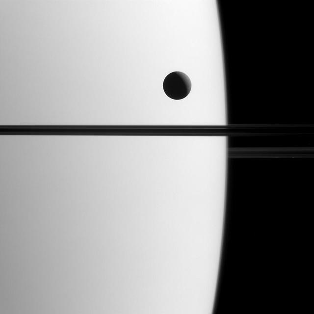 Saturn's moon Dione crosses the face of the giant planet in this view, a phenomenon astronomers call a transit. Transits play an important role in astronomy and can be used to study the orbits of planets and their atmospheres, both in our solar system and in others.  By carefully timing and observing transits in the Saturn system, like that of Dione (698 miles or 1123 kilometers across), scientists can more precisely determine the orbital parameters of Saturn's moons.  This view looks toward the unilluminated side of the rings from about 0.3 degrees below the ring plane. The image was taken in visible green light with the Cassini spacecraft narrow-angle camera on May 21, 2015.  The view was acquired at a distance of approximately 1.4 million miles (2.3 million kilometers) from Saturn and at a Sun-Saturn-spacecraft, or phase, angle of 119 degrees. Image scale is 9 miles (14 kilometers) per pixel.  http://photojournal.jpl.nasa.gov/catalog/PIA18330