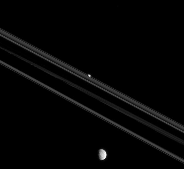 Although Mimas and Pandora, shown here, both orbit Saturn, they are very different moons. Pandora, "small" by moon standards (50 miles or 81 kilometers across) is elongated and irregular in shape. Mimas (246 miles or 396 kilometers across), a "medium-sized" moon, formed into a sphere due to self-gravity imposed by its higher mass. The shapes of moons can teach us much about their history. For example, one explanation for Pandora's elongated shape and low density is that it may have formed by gathering ring particles onto a dense core. This view looks toward the unilluminated side of the rings from 0.26 degrees below the ring plane. The image was taken in visible light with the Cassini spacecraft narrow-angle camera on July 26, 2015. The view was obtained at a distance of approximately 485,000 miles (781,000 kilometers) from Pandora. Image scale is 3 miles (5 kilometers) per pixel. Mimas is 904,000 miles (1.4 million kilometers) from the spacecraft in this image. The scale on Mimas is 5.4 miles (8.4 kilometers) per pixel. http://photojournal.jpl.nasa.gov/catalog/PIA18339