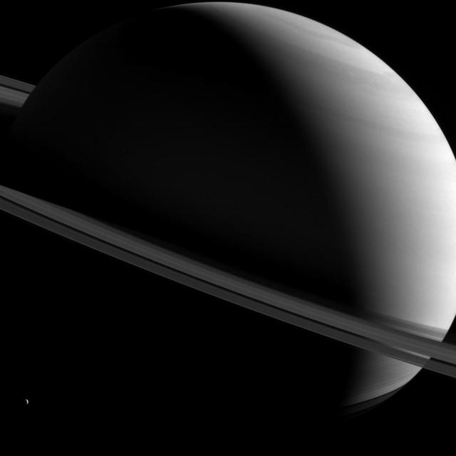 NASA Cassini spacecraft captured this image of Saturn as it views the planet and its expansive rings from all sorts of angles. Here, a half-lit Saturn sits askew as tiny Dione looks on from lower left.