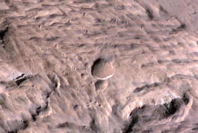The largest crater associated with a March 2012 impact on Mars has many smaller craters around it, revealed in this image from the High Resolution Imaging Science Experiment HiRISE camera on NASA Mars Reconnaissance Orbiter.