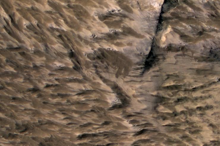 This April 6, 2014, image from NASA Mars Reconnaissance Orbiter shows numerous landslides in the vicinity of where an impact crater was excavated in March 2012.
