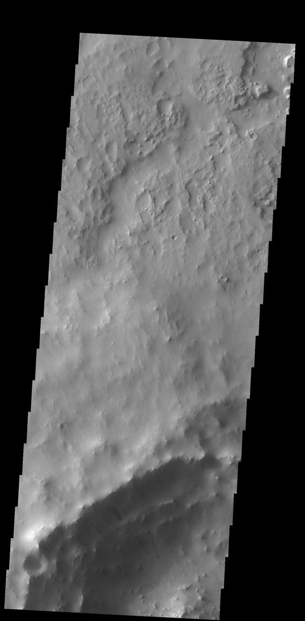 Dark slope streaks mark the rim of this unnamed crater in Terra Sabaea, as shown in this image captured by NASA 2001 Mars Odyssey spacecraft.
