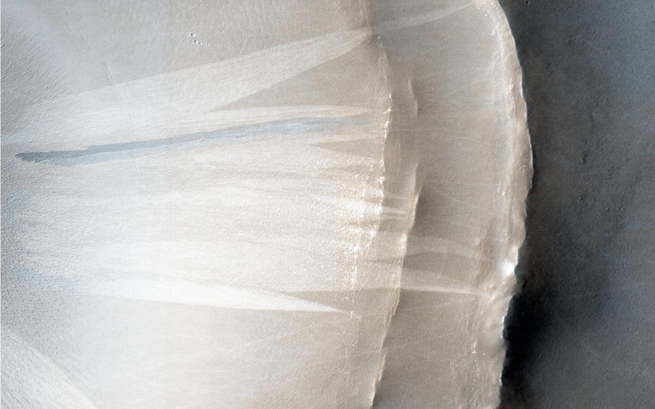 This image from NASA Mars Reconnaissance Orbiter shows features commonly found in dusty areas: impacts, slope streaks and bed-forms.