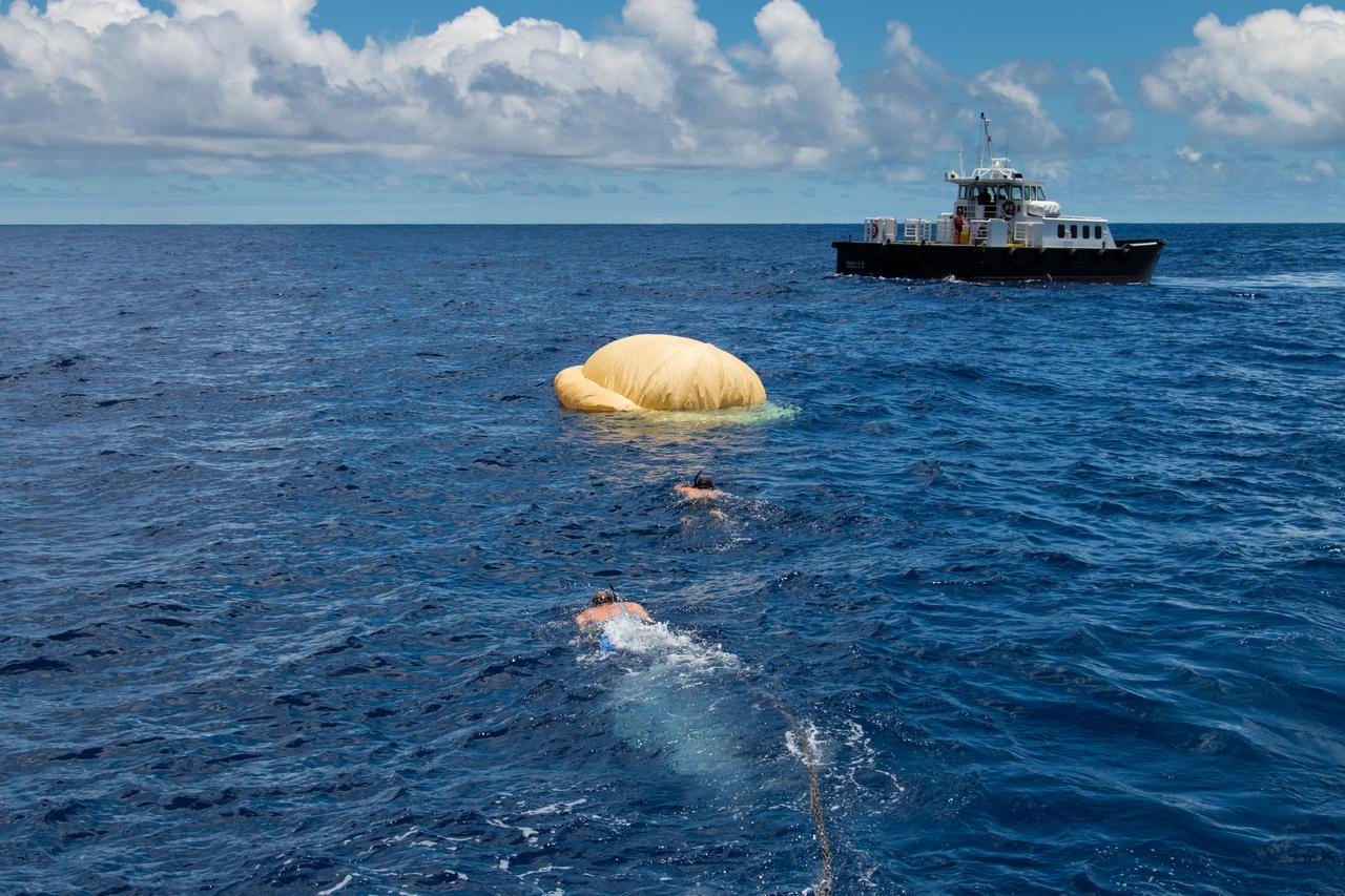 Hours after the June 28, 2014, test of NASA Low-Density Supersonic Decelerator over the U.S. Navy Pacific Missile Range, two members of the Navy Explosive Ordinance Disposal swim toward the test vehicle.