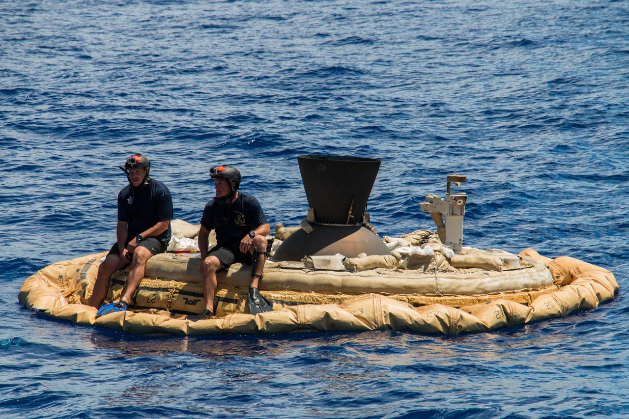 Two members of the Navy Explosive Ordinance Disposal team perch on the test vehicle used in the first flight of NASA Low-density Supersonic Decelerator project.