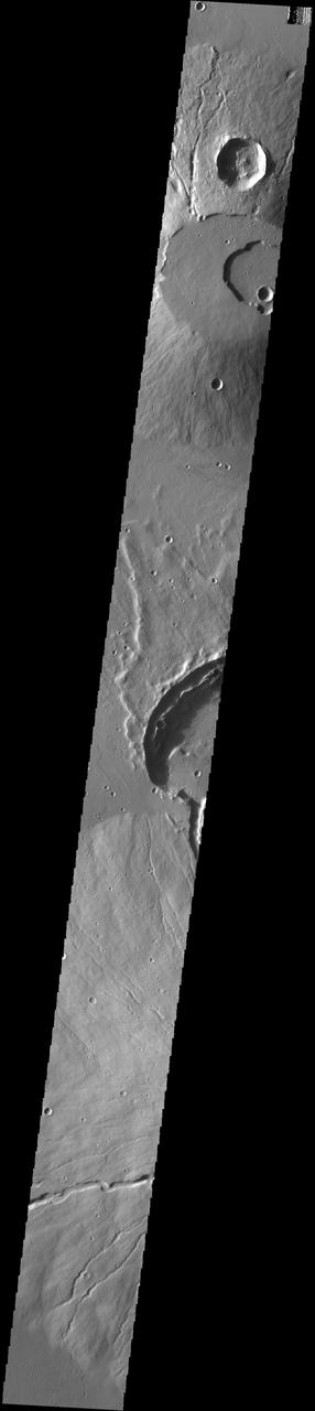 This image captured by NASA 2001 Mars Odyssey spacecraft crosses the summit of Uranius Tholus, as well as the western flank of Ceraunius Tholus.