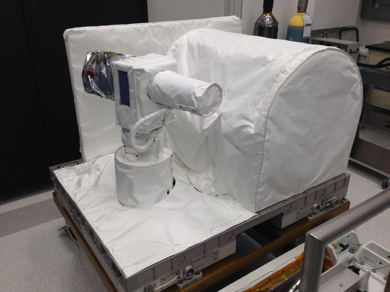 Optical PAyload for Lasercomm Science OPALS is covered in white thermal blankets awaiting integration with its launch vehicle at NASA Kennedy Space Center.