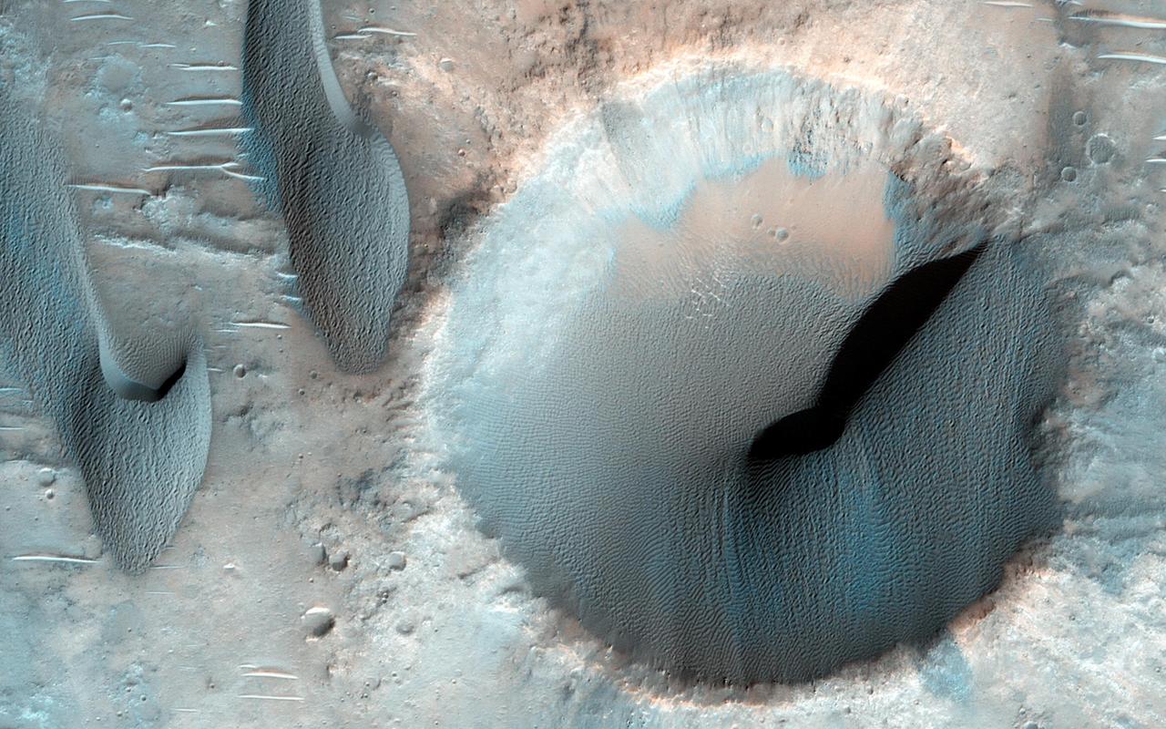 This image NASA Mars Reconnaissance Orbiter shows dozens of dark-toned dunes in and around several craters within the rugged terrain of Terra Cimmeria.