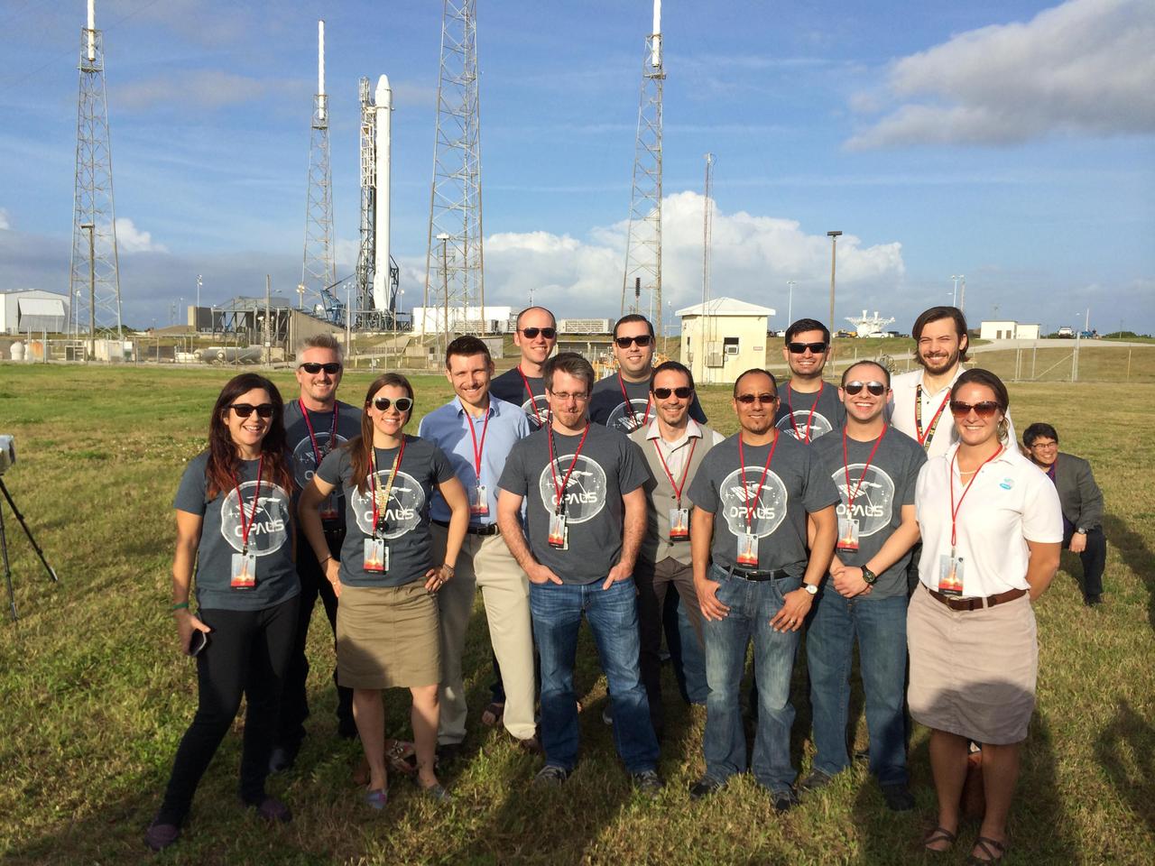 NASA Optical PAyload for Lasercomm Science OPALS operations team at Kennedy Space Center Space Launch Complex-40 on April 14, 2014, with the SpaceX Falcon 9 rocket carrying OPALS in the background.