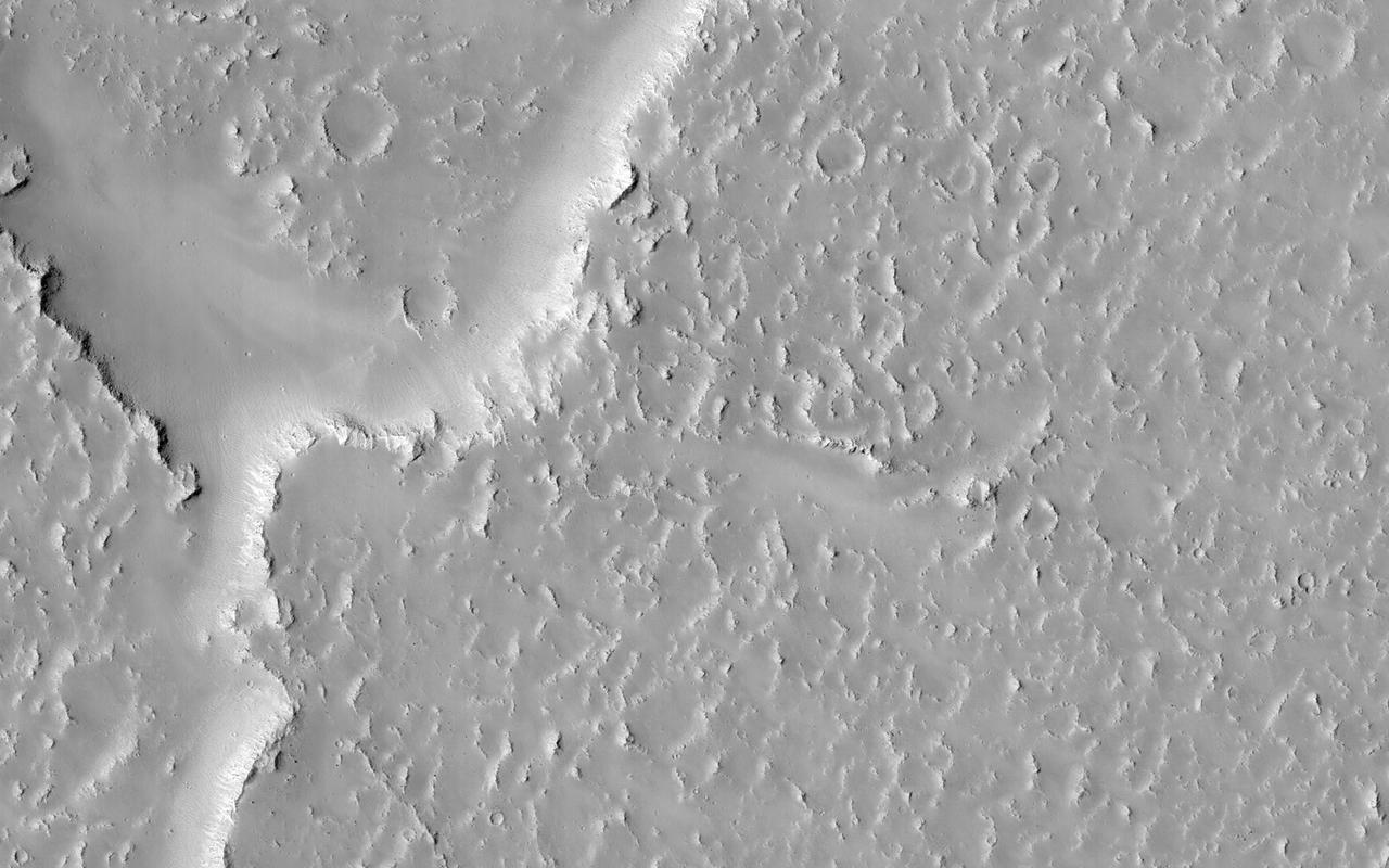 Lava flows south of Arsia Mons in Daedalia Planum transition from younger flows with elongated, sinuous morphologies to the northeast, to older, broader lobes and sheet flows to the southwest. This image is from NASA Mars Reconnaissance Orbiter.