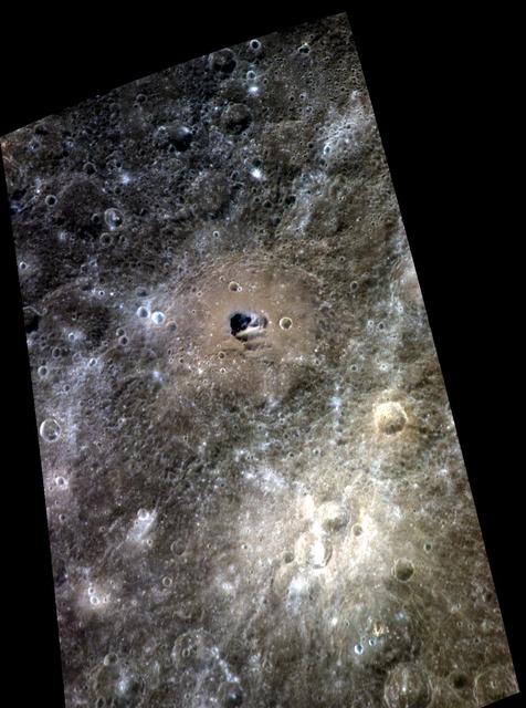 Hemingway crater is seen in this color view of Mercury surface as seen by NASA MESSENGER spacecraft. Hemingway is the 130-km 81-mile diameter crater with a relatively brown floor and small patch of dark blue in its center.