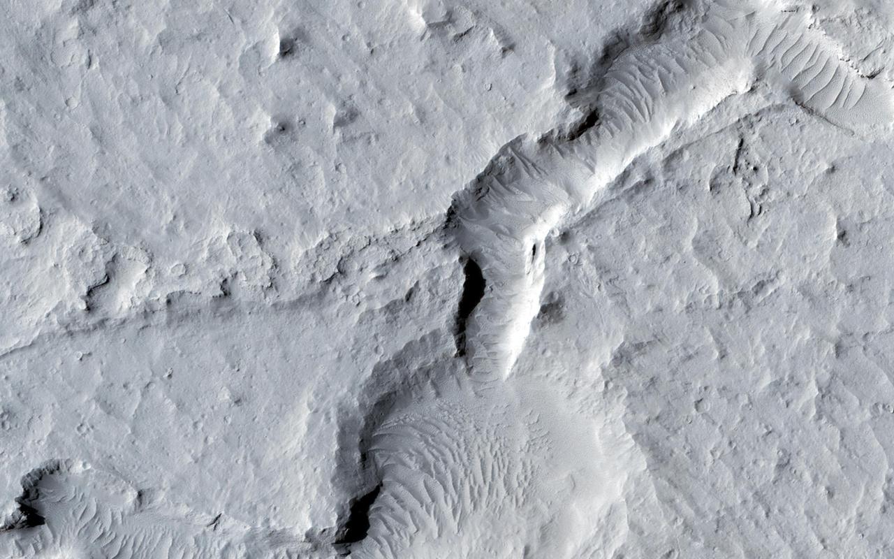 In the northern section of this from image NASA Mars Reconnaissance Orbiter, we see flat terrain that is probably an ancient lava field. These dust avalanches are common in dust-covered regions on Mars.