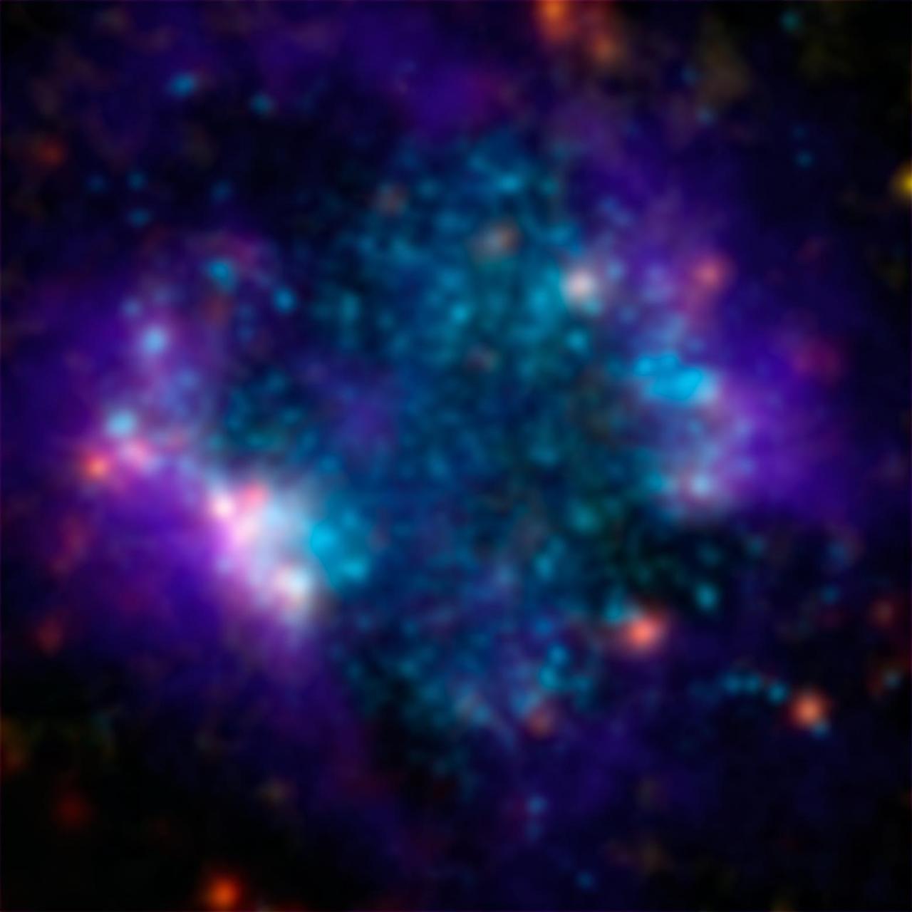 A small galaxy, called Sextans A, is shown here in a multi-wavelength mosaic captured by the ESA Herschel mission. In this image, the purple shows gas; blue shows young stars and the orange and yellow dots are newly formed stars heating up dust.