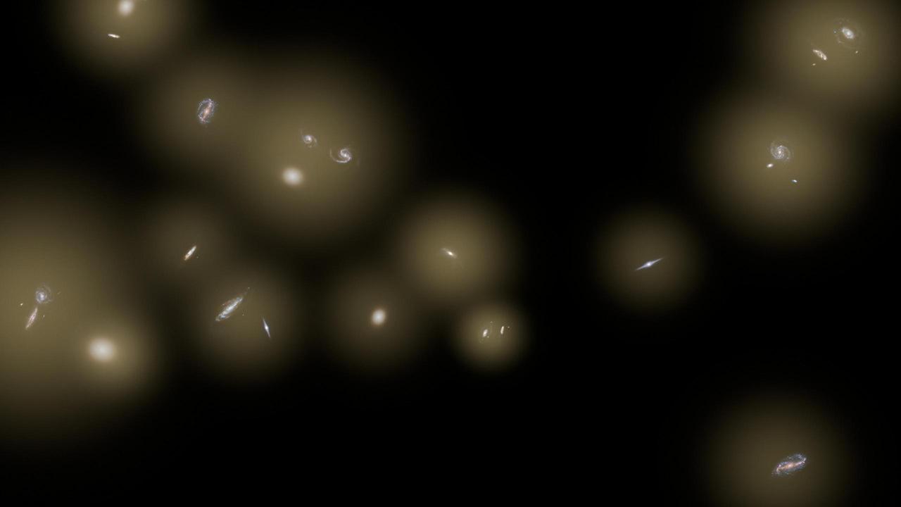This artist concept shows a view of a number of galaxies sitting in huge halos of stars. The stars are too distant to be seen individually and instead are seen as a diffuse glow, colored yellow in this illustration.