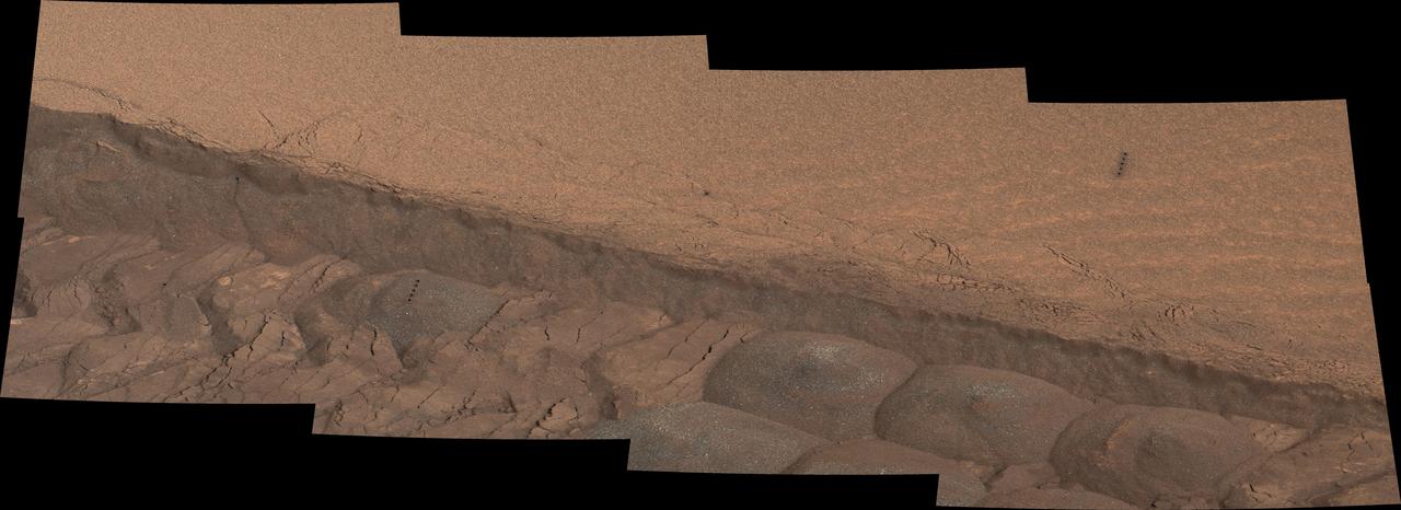 A wheel track cuts through a windblown ripple of dusty sand in this Nov. 7, 2014, image from the Mastcam on NASA Curiosity rover. The view spans about four feet across.