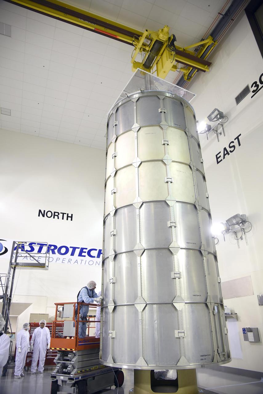 In the Astrotech payload processing facility on Vandenberg Air Force Base in California, technicians secure a transportation canister around NASA Soil Moisture Active Passive SMAP spacecraft for its move to the launch pad.
