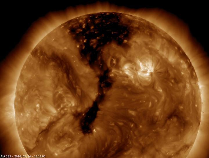 NASA Solar Dynamics Observatory shows a long coronal hole has rotated so that was temporarily facing right towards Earth Mar. 23-25, 2016. Coronal holes appear dark when viewed in some wavelengths of extreme ultraviolet light.