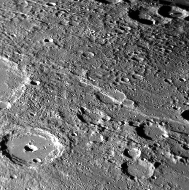 Lessing crater can be seen in the lower left of this image. Instead of the typical central peak found in a complex crater on Mercury, Lessing sports a central pit, likely formed by volcanic activity. A large tectonic scarp that formed when the planet's interior cooled and contracted can be seen running through a crater near the center of the image. http://photojournal.jpl.nasa.gov/catalog/PIA19276