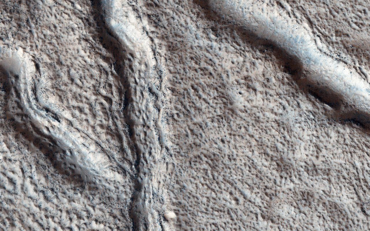 This observation from NASA Mars Reconnaissance Orbiter shows the nature of large fissures in a smooth apron around a mound in the Phlegra region. The apron could be (or could have been) ice-rich, so one possibility is that the fissures are related to ice loss. Based on radar data from MRO combined with studies of the region's geology from other orbiters, scientists think that extensive glaciers covered this region several hundred million years ago. http://photojournal.jpl.nasa.gov/catalog/PIA19307