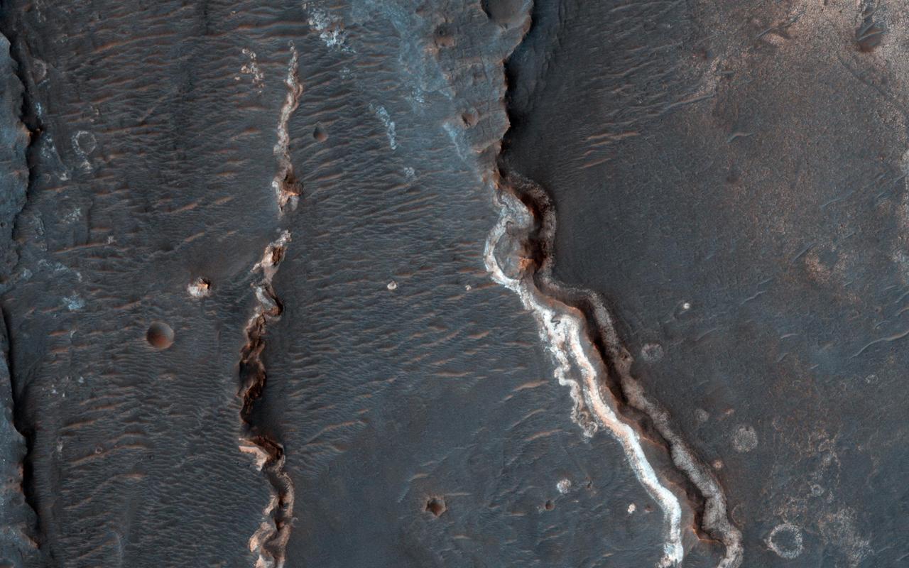 This observation from NASA Mars Reconnaissance Orbiter shows an interesting crater floor with what appear to be inverted channels, rounded lobe-like landforms, and light-toned layered deposits along the southern portion of the crater wall. High resolution can help study the layers, with an enhanced-color image showing us any variations in composition between those light-toned layers and the darker-toned surfaces. http://photojournal.jpl.nasa.gov/catalog/PIA19353