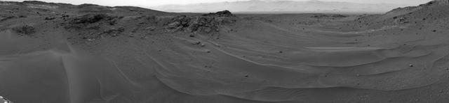 NASA's Curiosity Mars rover used its Navigation Camera (Navcam) to capture this scene toward the west just after completing a drive that took the mission's total driving distance past 10 kilometers (6.214 miles). The drive on April 16, 2015, during the 957th Martian day, or sol of Curiosity's work on Mars covered 208 feet (63.5 meters). It advanced the rover westward through a sandy-floored valley. The valley is on the rover's route toward a higher site on Mount Sharp than sites it has investigated previously. http://photojournal.jpl.nasa.gov/catalog/PIA19391