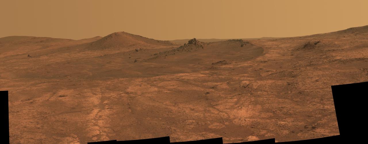An elongated crater called "Spirit of St. Louis," with a rock spire in it, dominates a recent scene from the panoramic camera (Pancam) on NASA's Mars Exploration Rover Opportunity.  Opportunity completed its 4,000 Martian day, or sol, of work on Mars on April 26, 2015. The rover has been exploring Mars since early 2004.  This scene from late March 2015 shows a shallow crater called Spirit of St. Louis, about 110 feet (34 meters) long and about 80 feet (24 meters) wide, with a floor slightly darker than surrounding terrain. The rocky feature toward the far end of the crater is about 7 to 10 feet (2 to 3 meters) tall, rising higher than the crater's rim.  The component images of this mosaic view were taken on March 29 and 30, 2015, during Sol 3973 and Sol 3974 of the mission. This version of the image is presented in approximate true color by combing exposures taken through three of the Pancam's color filters, centered on wavelengths of 753 nanometers (near-infrared), 535 nanometers (green) and 432 nanometers (violet). The unusually shaped Spirit of St. Louis Crater lies on the outer portion of the western rim of Endeavour Crater. Endeavour spans about 14 miles (22 kilometers) in diameter, and Opportunity has been exploring its western rim for about one-third of the rover's mission, which has lasted more than 11 years. Endeavour's elevated western rim extends northward to the left from Spirit of St. Louis Crater in this scene. A glimpse to the far side of Endeavour is visible on either side of the rock spire.  http://photojournal.jpl.nasa.gov/catalog/PIA19393