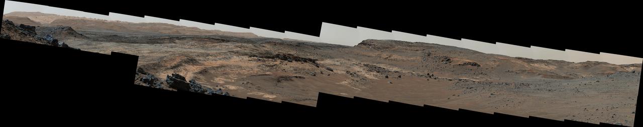 A sweeping panorama combining 33 telephoto images into one Martian vista presents details of several types of terrain visible on Mount Sharp from a location along the route of NASA's Curiosity Mars rover.  The rover's Mast Camera (Mastcam) recorded the component images with its right-eye camera on April 10, 2015, during the 952nd Martian day, or sol, of Curiosity's work on Mars, before that sol's drive. The panorama spans from south-southeast, at left, to west-southwest. The color has been approximately white-balanced to resemble how the scene would appear under daytime lighting conditions on Earth.  Higher elevations on Mount Sharp are visible at left, including the jagged skyline to the right of a 100-meter scale bar overlaid on the image. (One hundred meters is about 328 feet.) The 2-meter (7-foot) scale bar near the center of the scene is on an exposure of pale mudstone within Mount Sharp's basal geological unit, the Murray formation, and nearby darker rocks. The 3-meter (10-foot) scale bar farther to the right is at the base of a rise called "Gray Wolf Peak." "Logan Pass," a science destination for the rover, is at a dip on the horizon near the right edge of the panorama.   Malin Space Science Systems, San Diego, built and operates the rover's Mastcam. NASA's Jet Propulsion Laboratory, a division of the California Institute of Technology, Pasadena, manages the Mars Science Laboratory Project for NASA's Science Mission Directorate, Washington. JPL designed and built the project's Curiosity rover.  http://photojournal.jpl.nasa.gov/catalog/PIA19397