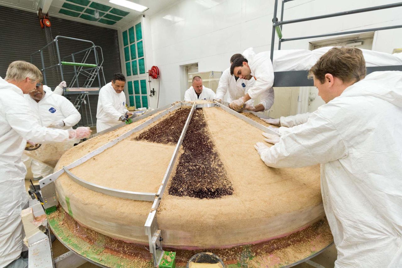 In this February 2015 scene from a clean room at Lockheed Martin Space Systems, Denver, specialists are building the heat shield to protect NASA's InSight spacecraft when it is speeding through the Martian atmosphere.  Note: After thorough examination, NASA managers have decided to suspend the planned March 2016 launch of the Interior Exploration using Seismic Investigations Geodesy and Heat Transport (InSight) mission. The decision follows unsuccessful attempts to repair a leak in a section of the prime instrument in the science payload.  http://photojournal.jpl.nasa.gov/catalog/PIA19404