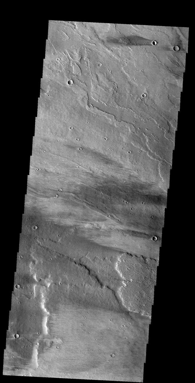 This image captured by NASA 2001 Mars Odyssey spacecraft shows windstreaks on the lava flows of Daedalia Planum. The tail behind the crater indicates winds blew from east to west. Orbit Number: 59116 Latitude: -12.3936 Longitude: 219.568 Instrument: VIS Captured: 2015-04-12 07:37 http://photojournal.jpl.nasa.gov/catalog/PIA19498