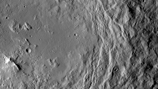 NASA's Dawn spacecraft took this image that shows a mountain ridge, near lower left, that lies in the center of Urvara crater on Ceres. Urvara is an Indian and Iranian deity of plants and fields. The crater's diameter is 101 miles (163 kilometers).  This view was acquired on August 19, 2015, from a distance of 915 miles (1,470 kilometers). The resolution of the image is 450 feet (140 meters) per pixel.  http://photojournal.jpl.nasa.gov/catalog/PIA19632