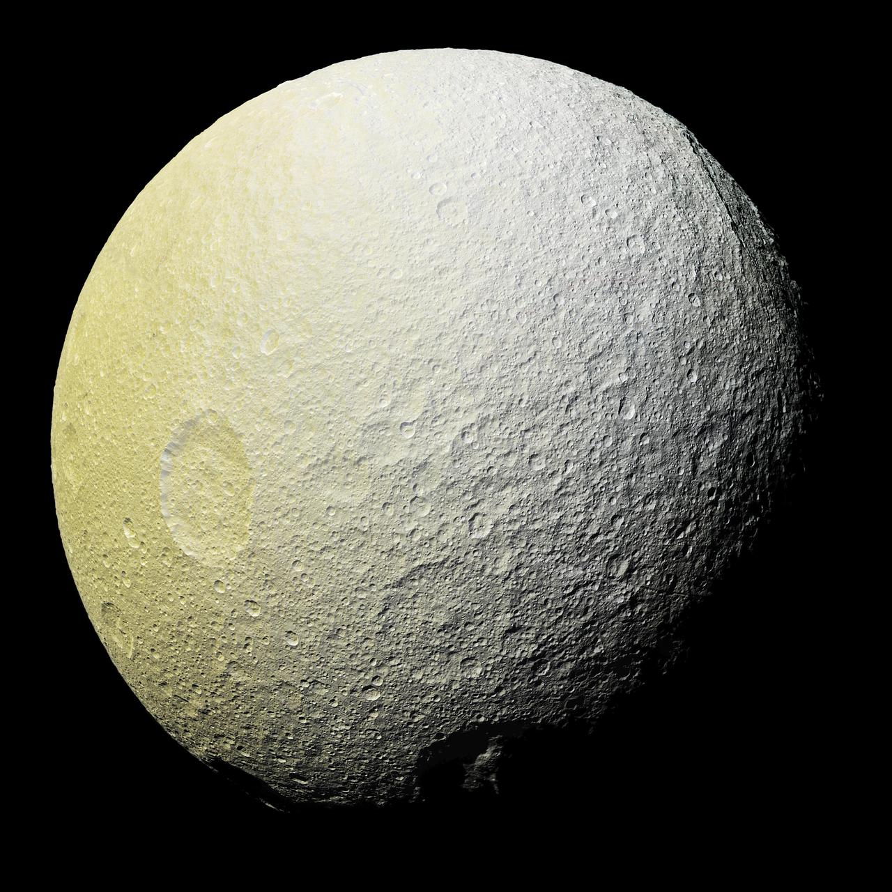 This enhanced-color mosaic of Saturn's icy moon Tethys shows a range of features on the moon's trailing hemisphere. Tethys is tidally locked to Saturn, so the trailing hemisphere is the side of the moon that always faces opposite its direction of motion as it orbits the planet. Images taken using clear, green, infrared and ultraviolet spectral filters were combined to create the view, which highlights subtle color differences across Tethys' surface at wavelengths not visible to human eyes. The moon's surface is fairly uniform in natural color. The color of the surface changes conspicuously across the disk, from yellowish hues to nearly white. These broad color changes are affected by a number of external processes. First, Saturn's diffuse E-ring preferentially bombards Tethys' leading hemisphere, toward the right side of this image, with ice bright ice grains. At the same time, charged particles from Saturn's radiation belt bombard the surface on the trailing side, causing color changes due to chemical alteration of the materials there. The albedo -- a measure of the surface's reflectivity -- drops by 10 to 15 percent from the moon's leading side to the trailing side. Similar global color patterns exist on other Saturnian moons. On a much smaller scale, enigmatic, arc-shaped, reddish streaks also are faintly visible across the heavily-cratered surface, particularly if one enhances color saturation in the image (see PIA19637 for a close-up view of these features). The origin of this localized color contrast is not yet understood. Mountains on the floor of the 280 mile- (450 kilometer-) wide Odysseus impact basin are visible at upper right, around the two o'clock position. This mosaic is an orthographic projection constructed from 52 Cassini images obtained on April 11, 2015 with the Cassini spacecraft narrow-angle camera. Resolution is about 1,000 feet (300 meters) per pixel. The images were obtained at a distance of approximately 33,000 miles (53,000 kilometers) from Tethys. http://photojournal.jpl.nasa.gov/catalog/PIA19636