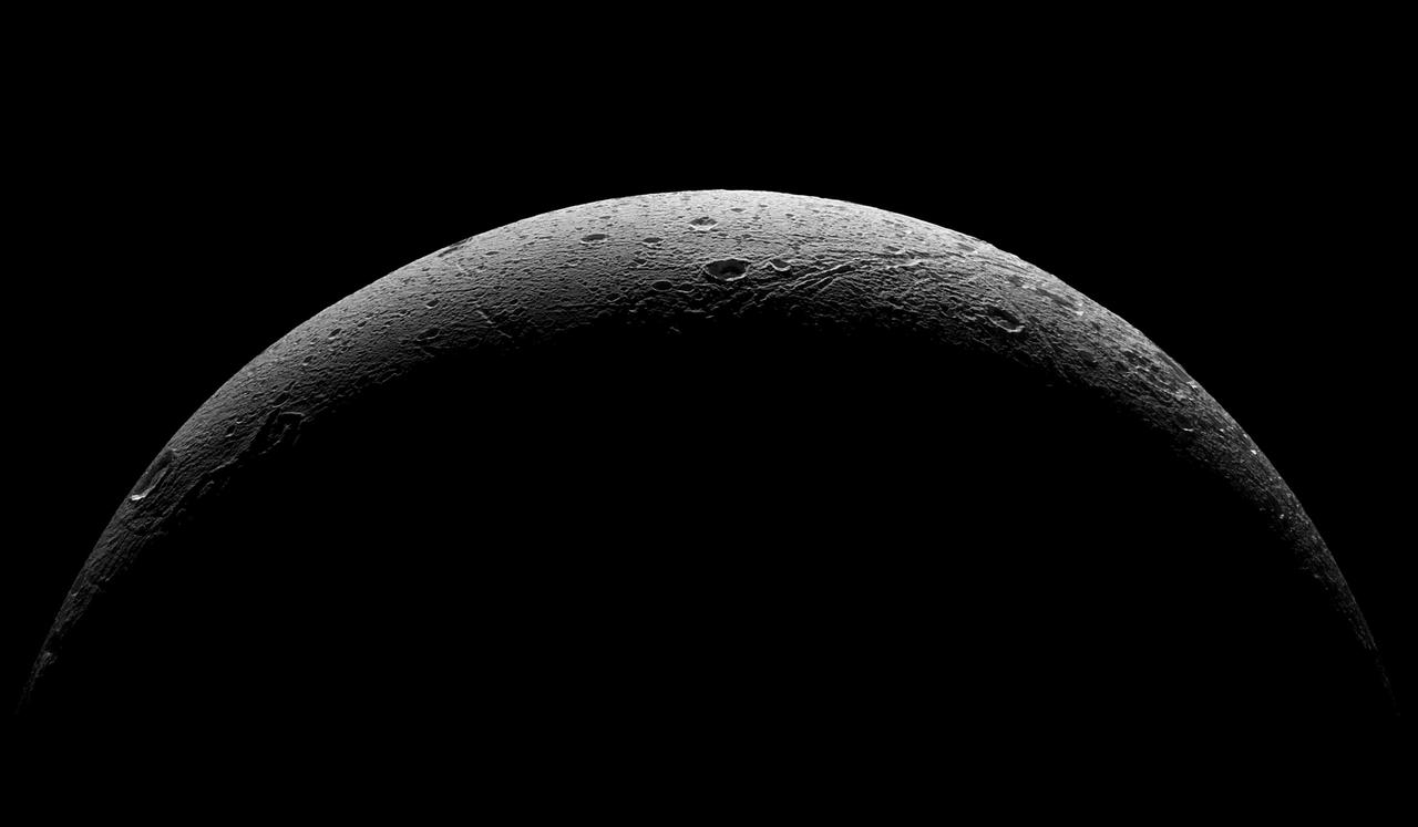NASA Cassini spacecraft captured this parting view showing the rough and icy crescent of Saturn moon Dione following the spacecraft last close flyby of the moon on Aug. 17, 2015.  Cassini obtained a similar crescent view in 2005 (see PIA07745). The earlier view has an image scale about four times higher, but does not show the moon's full crescent as this view does.  Five visible light (clear spectral filter), narrow-angle camera images were combined to create this mosaic view. The scene is an orthographic projection centered on terrain at 0.4 degrees north latitude, 30.6 degrees west longitude on Dione. An orthographic view is most like the view seen by a distant observer looking through a telescope.  The view was acquired at distances ranging from approximately 37,000 miles (59,000 kilometers) to 47,000 miles (75,000 kilometers) from Dione and at a sun-Dione-spacecraft, or phase, angle of 145 degrees. Image scale is about 1,300 feet (400 meters) per pixel.  North on Dione is up and rotated 34 degrees to the right.  http://photojournal.jpl.nasa.gov/catalog/PIA19649