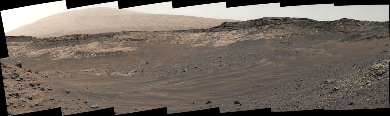 This view southeastward from Curiosity's Mast Camera (Mastcam) shows terrain judged difficult for traversing between the rover and an outcrop in the middle distance where a pale rock unit meets a darker rock unit above it.  The Mastcam's left-eye camera captured the component images on May 10, 2015, during the 981st Martian day, or sol, of Curiosity's work on Mars.  This observation helped the rover team evaluate routes for driving to that geological contact area where the two rock units meet. The outcrop exposing the contact is in the eastern portion of the "Logan Pass" area. The windblown ripples and the steep ground where ripples are lacking are both poor terrain for the rover to cross. The team subsequently chose to approach a different site where the pale and darker rock units are in contact with each other. That alternative site is in the northern portion of the Logan Pass area, outside of this scene.  This panorama spans from east, at left, to south-southwest. The color has been approximately white-balanced to resemble how the scene would appear under daytime lighting conditions on Earth.  http://photojournal.jpl.nasa.gov/catalog/PIA19662