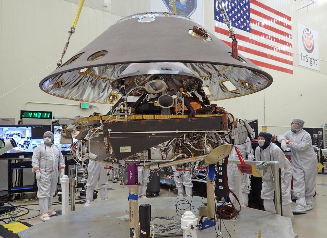 In this photo, the back shell of NASA's InSight spacecraft is being lowered onto the mission's lander, which is folded into its stowed configuration. The back shell and a heat shield form the aeroshell, which will protect the lander as the spacecraft plunges into the upper atmosphere of Mars. The photo was taken on April 29, 2015, in a spacecraft assembly clean room at Lockheed Martin Space Systems, Denver. InSight, for Interior Exploration Using Seismic Investigations, Geodesy and Heat Transport, is scheduled for launch in March 2016 and landing in September 2016. It will study the deep interior of Mars to advance understanding of the early history of all rocky planets, including Earth. Note: After thorough examination, NASA managers have decided to suspend the planned March 2016 launch of the Interior Exploration using Seismic Investigations Geodesy and Heat Transport (InSight) mission. The decision follows unsuccessful attempts to repair a leak in a section of the prime instrument in the science payload. http://photojournal.jpl.nasa.gov/catalog/PIA19666