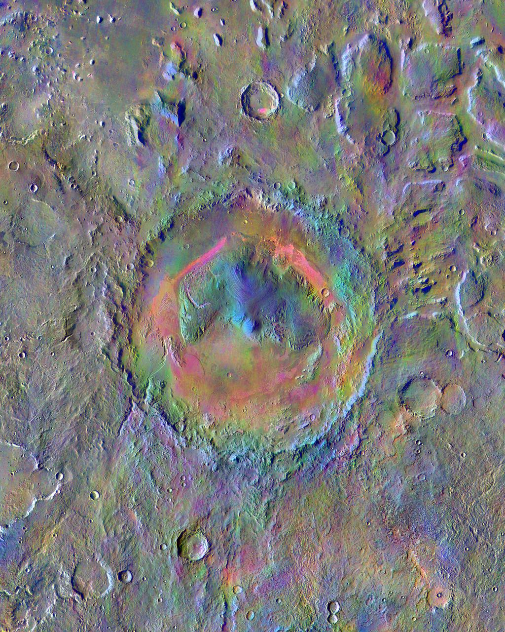 Gale Crater, home to NASA's Curiosity Mars rover, shows a new face in this mosaic image made using data from the Thermal Emission Imaging System (THEMIS) on NASA's Mars Odyssey orbiter. The colors come from an image processing technique that identifies mineral differences in surface materials and displays them in false colors. For example, windblown dust appears pale pink and olivine-rich basalt looks purple. The bright pink on Gale's floor appears due to a mix of basaltic sand and windblown dust. The blue at the summit of Gale's central mound, Mount Sharp, probably comes from local materials exposed there. The typical average Martian surface soil looks grayish-green. Scientists use false-color images such as these to identify places of potential geologic interest. The diameter of the crater is 96 miles (154 kilometers). North is up. THEMIS and other instruments on Mars Odyssey have been studying Mars from orbit since 2001. Curiosity landed in the northeastern portion of Gale Crater in 2012 and climbed onto the flank of Mount Sharp in 2014. http://photojournal.jpl.nasa.gov/catalog/PIA19674